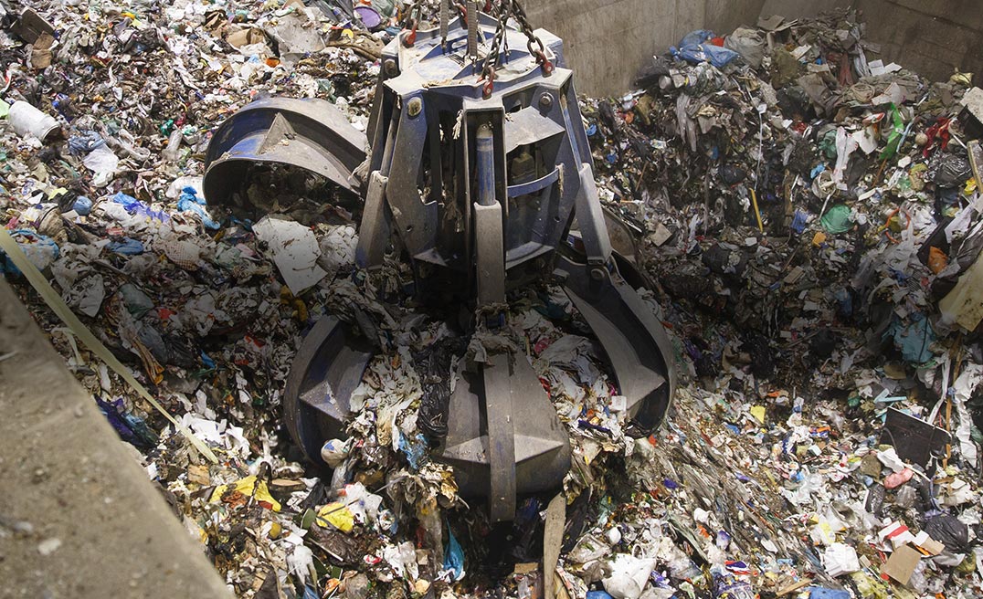 Un grappin qui prend des déchets dans une fosse